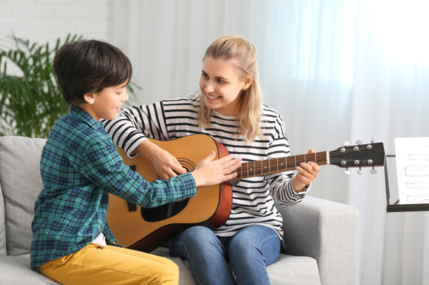 Prywatny nauczyciel muzyki daje lekcje gry na gitarze chłopcu w domu - Zdjęcie, obraz