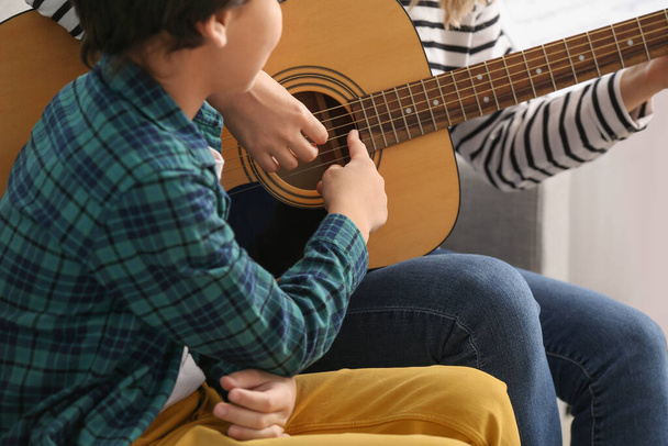 Private music teacher giving guitar lessons to little boy at home - Φωτογραφία, εικόνα