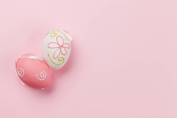 Húsvéti üdvözlőlap színes húsvéti tojással rózsaszín háttérrel. Top view lakás feküdt helyet az üdvözletét - Fotó, kép
