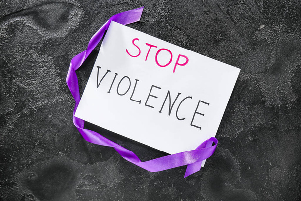 Violet ribbon and text STOP VIOLENCE on dark background - Foto, imagen