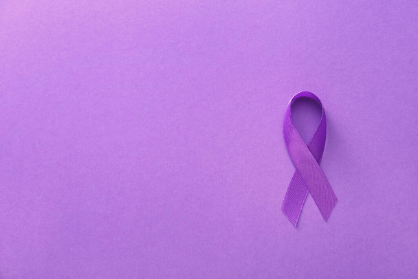 Violet ribbon on color background. Domestic violence concept - Fotografie, Obrázek