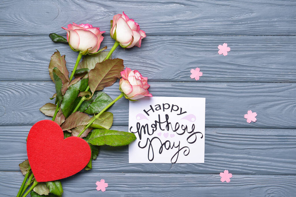Piękna kartka okolicznościowa i kwiaty na Dzień Matki na drewnianym tle - Zdjęcie, obraz