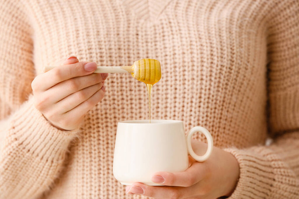 Woman drinking tea with honey, closeup - 写真・画像