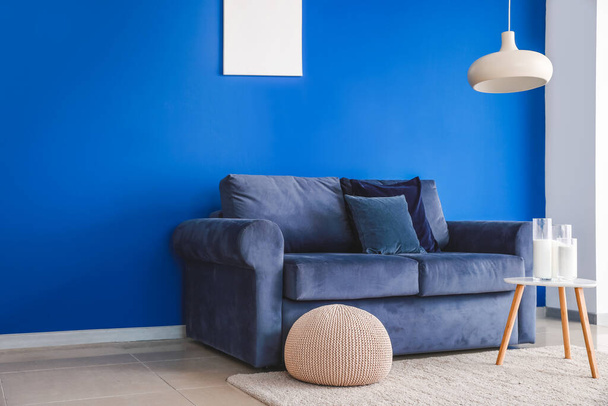 Mavi duvarın yanında yumuşak kanepesi olan modern oturma odasının içinde. - Fotoğraf, Görsel