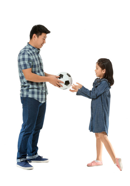 Happy Asian man and his little daughter with ball on white background - Foto, immagini