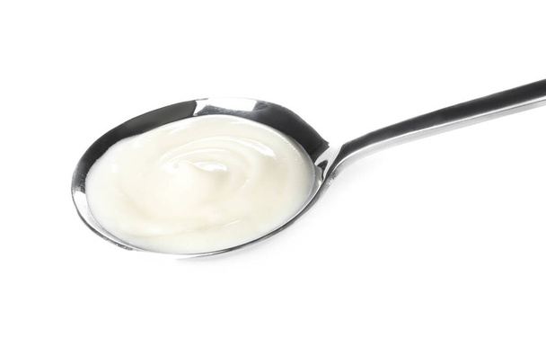 Cuchara con sabroso queso crema sobre fondo blanco
 - Foto, imagen