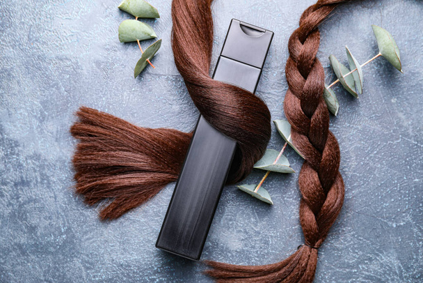 Brins de cheveux et shampooing à l'extrait de plantes sur fond gris
 - Photo, image