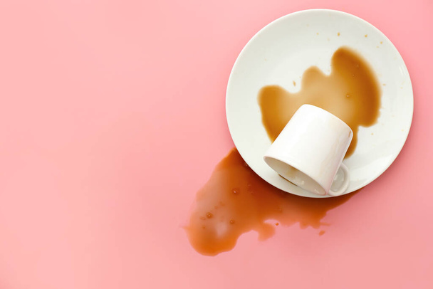 Umgestürzte Tasse Kaffee auf farbigem Hintergrund - Foto, Bild