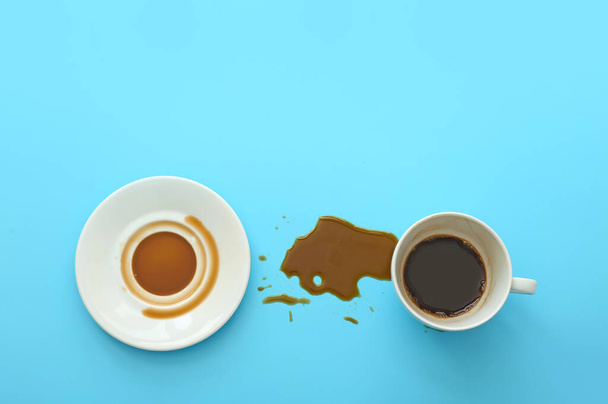 Kupa, csészealj és kiömlött kávé színes háttér - Fotó, kép