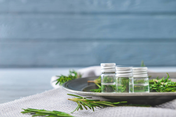 Bottles of rosemary essential oil on table - Foto, Imagem