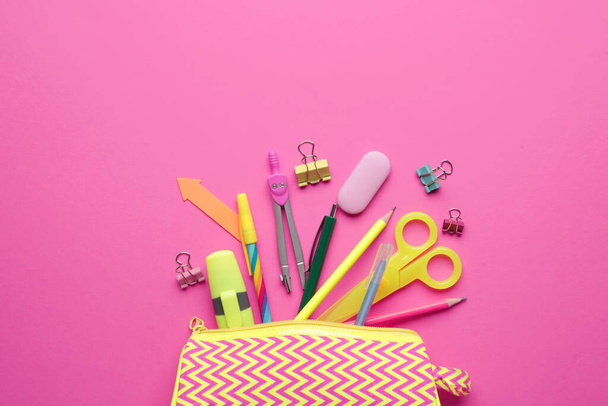 Pencil case and stationery on color background - Foto, imagen