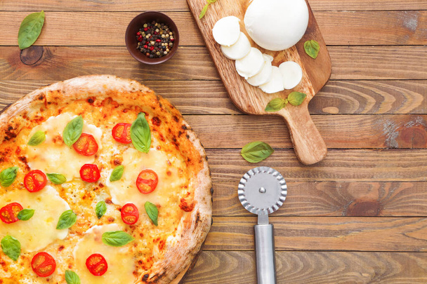 Složení s lahodnou pizzu Margherita na dřevěné pozadí - Fotografie, Obrázek