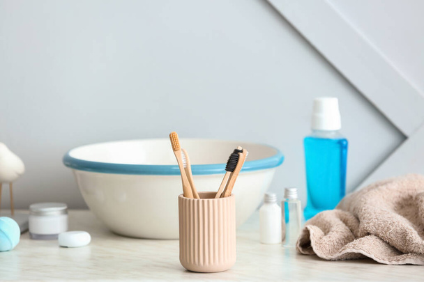 Зубні щітки в тримачі на столі у ванній
 - Фото, зображення