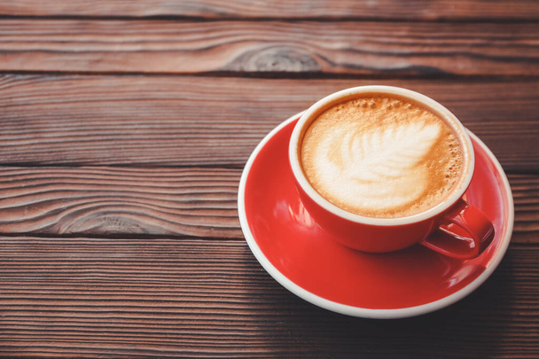 Xícara de cappuccino saboroso na mesa de madeira
 - Foto, Imagem