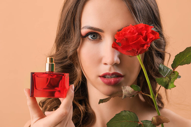 Beautiful young woman with bottle of perfume and flower on color background, closeup - Valokuva, kuva