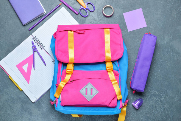 School backpack and stationery on grey background - Photo, Image