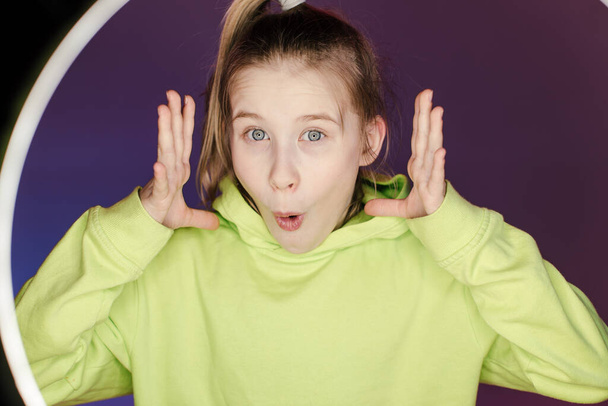 Junge stilvolle Mädchen im Studio auf einem farbigen Neon-Hintergrund. Musik-DJ-Plakatgestaltung. Porträt einer jungen Tänzerin. - Foto, Bild