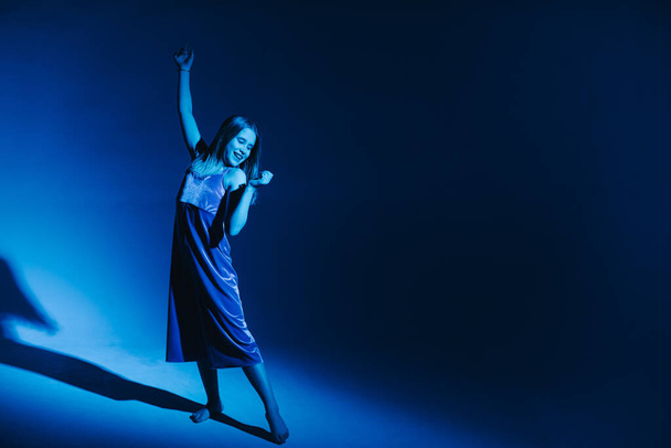 Stüdyoda renkli neon bir arka planda dans eden zarif genç bir kız. Klasik dansçı.. - Fotoğraf, Görsel
