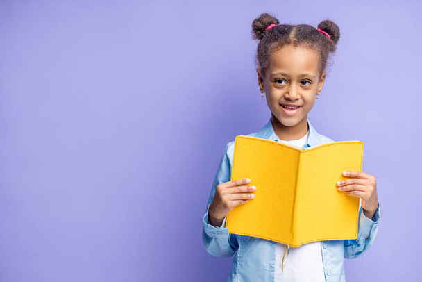 happy mulatto school child with book isolated - Foto, afbeelding