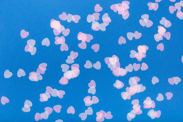 Confetti hearts on a blue background. Flat lay, copy space, top view. Holiday concept. - Photo, Image