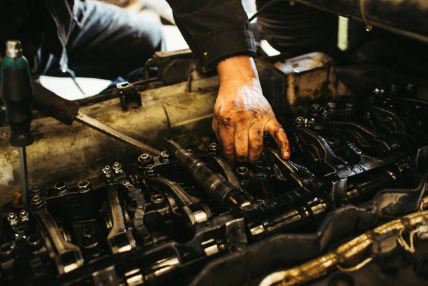  auto mechanic works on the engine - Фото, изображение