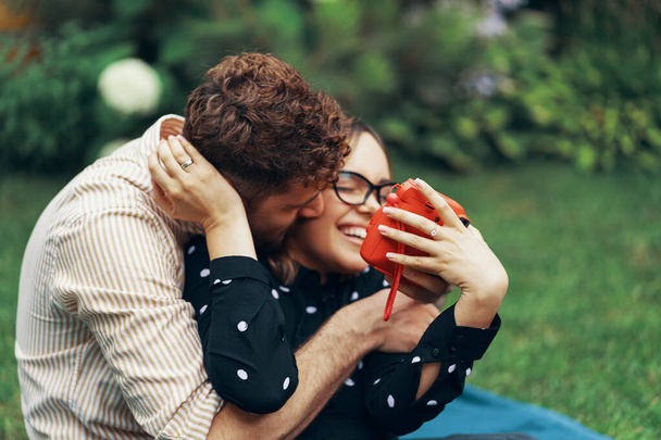 Jeune couple amoureux prenant un selfie avec un appareil photo instantané. Allongé sur l'herbe dans la cour de sa maison
 - Photo, image