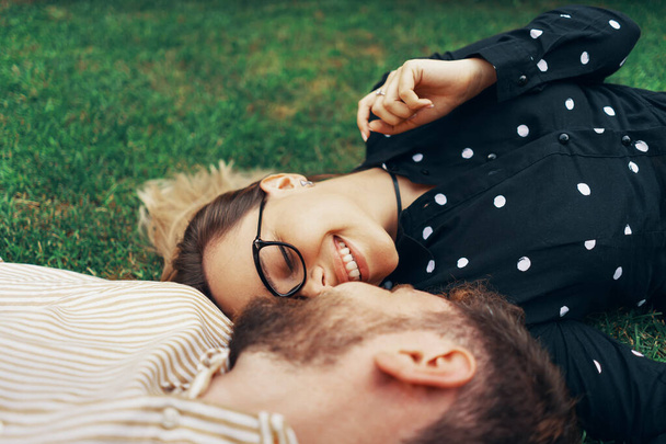 Couple amoureux couché sur l'herbe dans la cour de leur propre maison. Vue du haut
 - Photo, image
