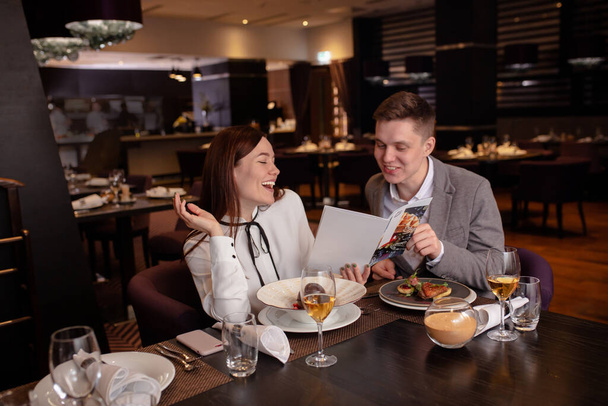 young couple reading menu in rich restaurant - Photo, image
