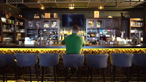 un homme est assis derrière un bar et prend un selfie
 - Séquence, vidéo