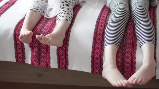 Zbliżenie dziecięcych stóp na kanapie - Materiał filmowy, wideo