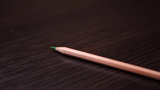 鉛筆は順番に木製のテーブルの上に置かれます。 - 映像、動画