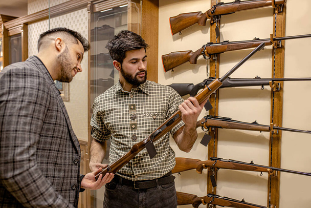 young men discuss weapon in store - Foto, imagen