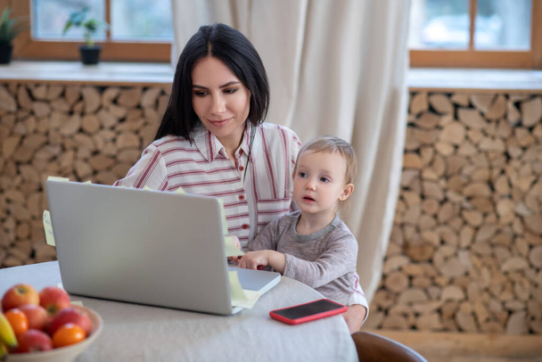 Young mom and daughter sitting at laptop - Foto, Imagem