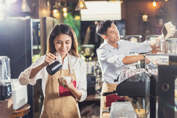Asian Barista przygotowuje filiżankę kawy, espresso z latte lub cappuccino na zamówienie klienta w kawiarni, barman wylewa mleko, właściciel małej firmy i startup w kawiarni i koncepcji restauracji - Zdjęcie, obraz