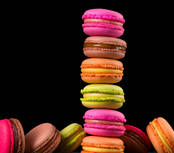 Stack of french colorful macaroons on wooden table isolated on black background - Φωτογραφία, εικόνα