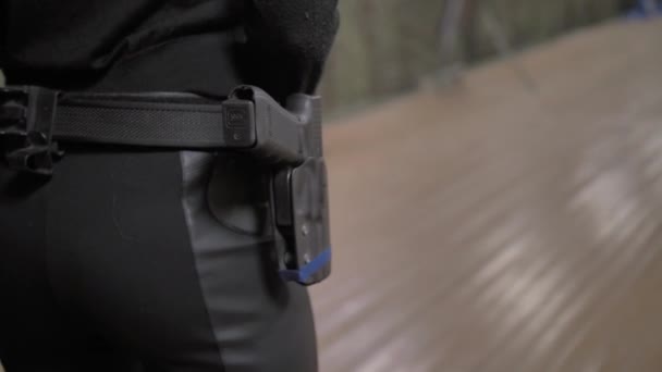Girl in black clothes takes out a gun from a holster and shoots - Filmagem, Vídeo