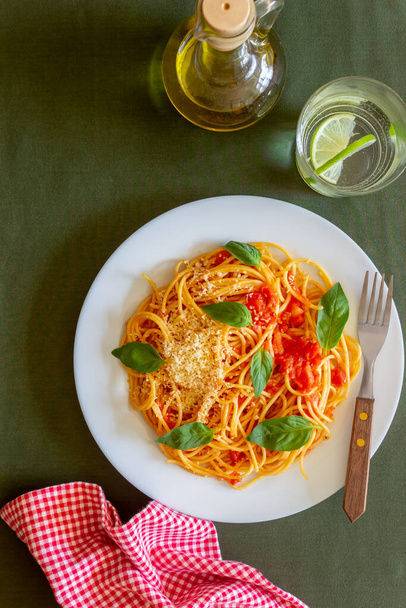 Esparguete de massa com tomate, manjericão e queijo parmesão. Cozinha italiana. Receita. Comida vegetariana. Alimentação saudável
 - Foto, Imagem