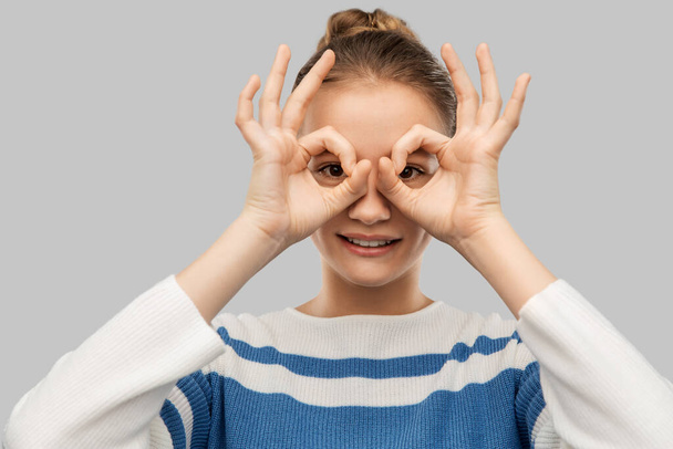 teenage girl looking through finger glasses - Fotó, kép