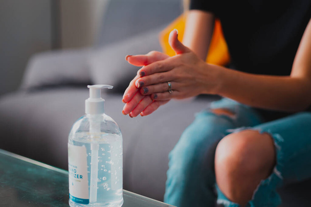 Nuori henkilö pesee kädet käyttäen sanitointiainetta
 - Valokuva, kuva