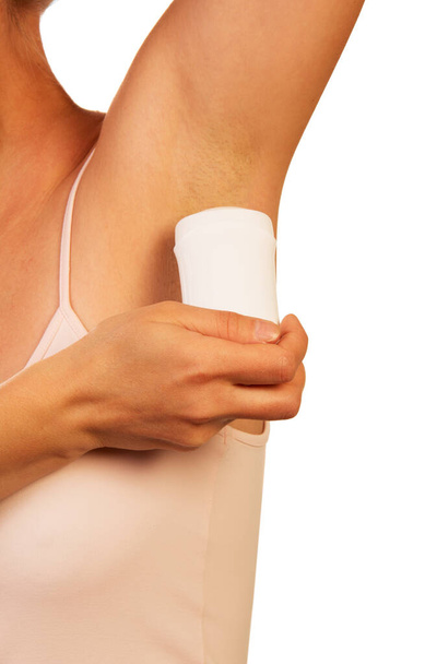 An unknown woman uses a dry underarm deodorant isolated on white background. - 写真・画像