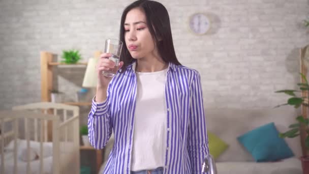 young asian woman drinks from a glass and is dissatisfied with the quality of water - Video, Çekim