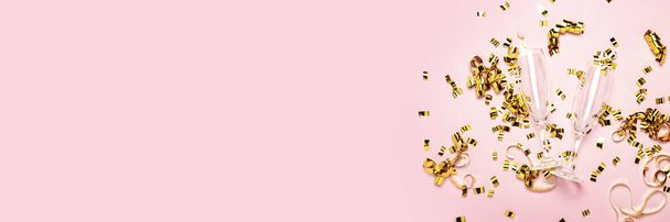 два пустых бокала шампанского и золотые конфетти, разбросанные на бледно-розовом фоне. Свадебная концепция, день рождения, годовщина, вечеринка, девичник. Баннер
. - Фото, изображение