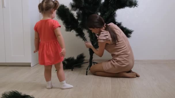 happy mom and daughter collect christmas tree at home. Christmas and New Year preparation - Footage, Video