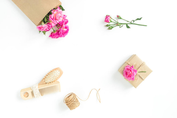 Composición de belleza de rosas con cepillo, borla y regalo sobre fondo blanco. Piso tendido, vista superior
 - Foto, Imagen