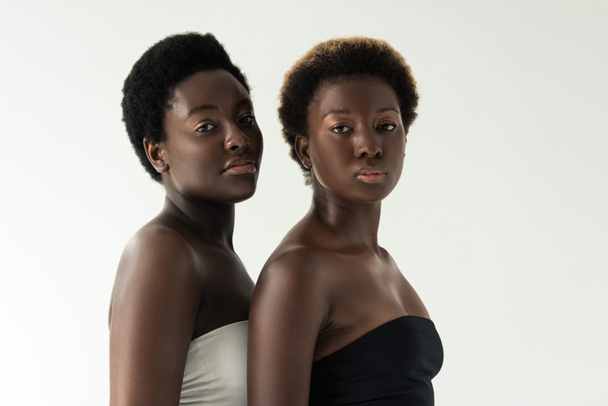 ελκυστικές αφρικανικές αμερικανίδες κοπέλες σε κορυφές απομονωμένες σε γκρι  - Φωτογραφία, εικόνα