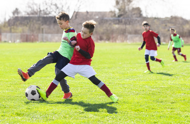 Los chicos juegan al fútbol en el campo - Foto, imagen
