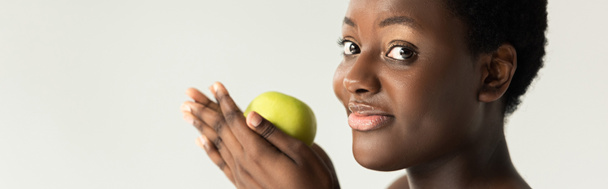 灰色で隔離された緑のリンゴを持つ幸せなアフリカ系アメリカ人女性のパノラマ写真 - 写真・画像