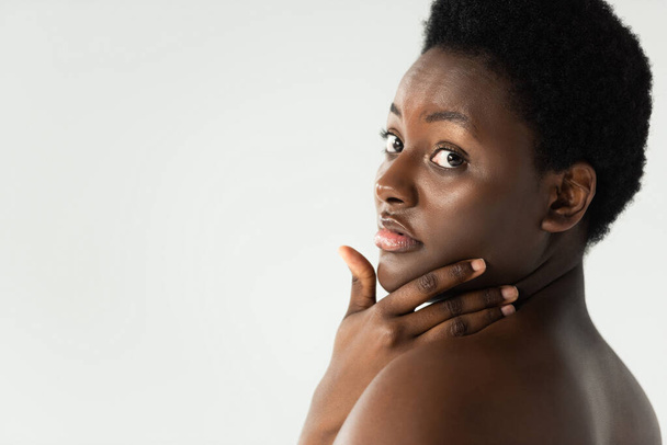 atractiva mujer afroamericana desnuda tocando la cara aislada en gris
 - Foto, Imagen