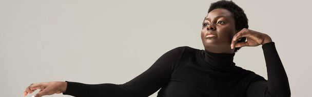 panoramic shot of attractive african american woman in black turtleneck isolated on grey - Fotografie, Obrázek