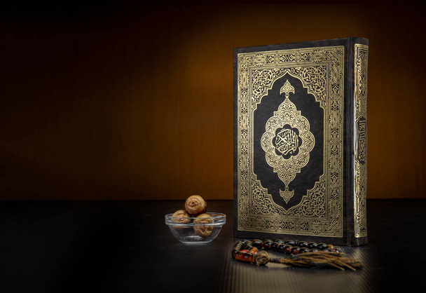 Heilig Boek van de koran met rozenkrans en data op zwarte achtergrond, het vieren van de Heilige Maand van de Ramadan - Foto, afbeelding